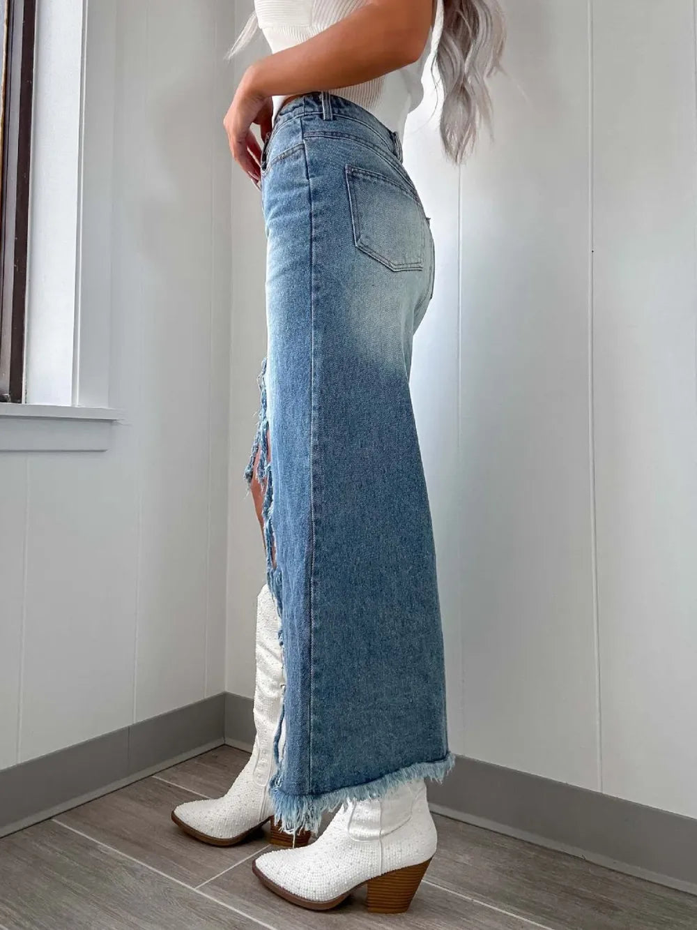 High-waist raw hem asymmetrical denim skirt by Trendsi featuring distressed edges and a stylish, modern cut.