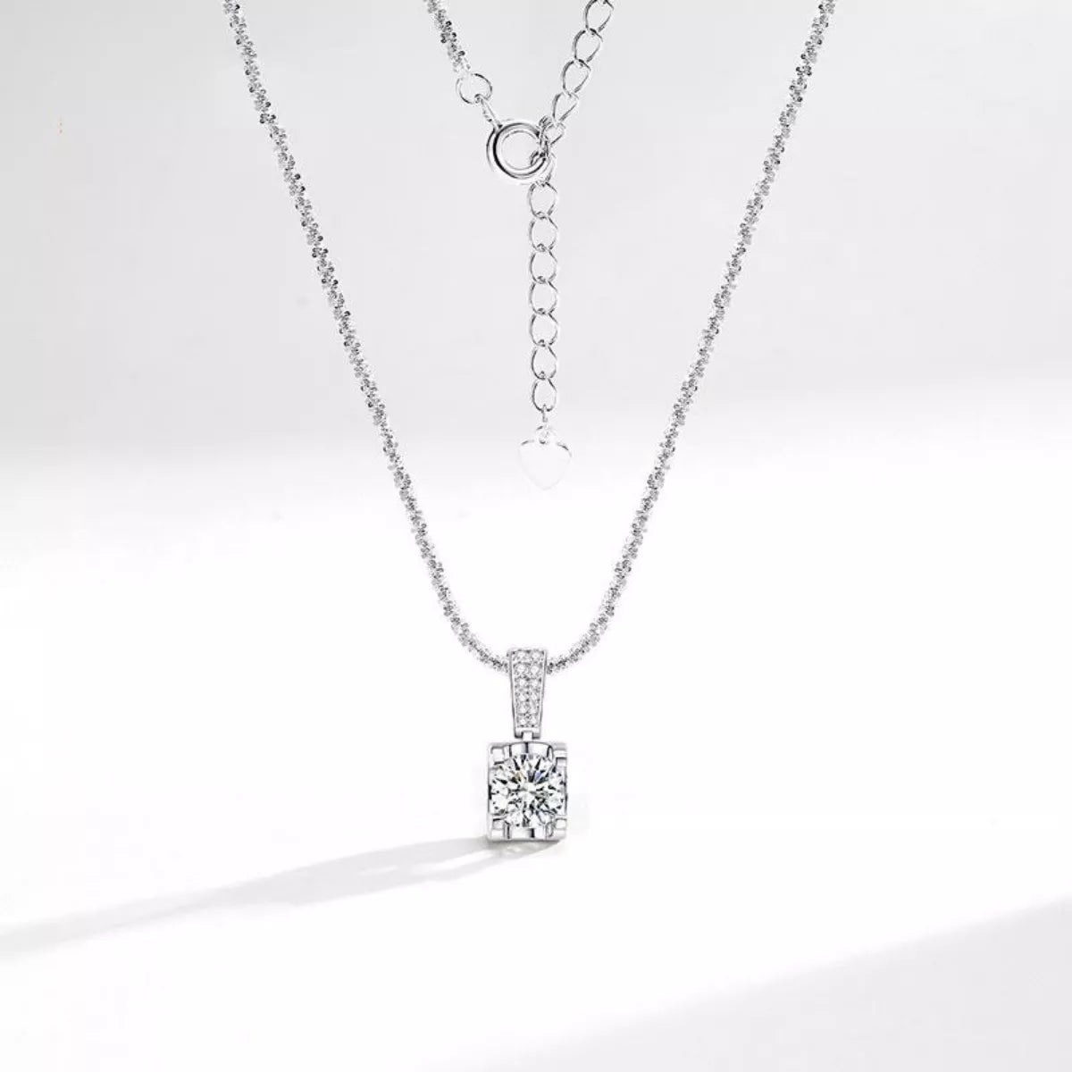 Sterling silver 1 carat moissanite necklace with a sparkling gemstone pendant, elegant jewelry piece.