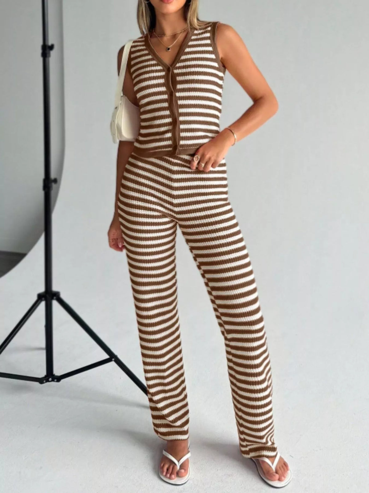 Striped knit V-neck sleeveless top and flare pants set by Plush Fashion Hub, featuring a stylish sleeveless design and colorful stripes.