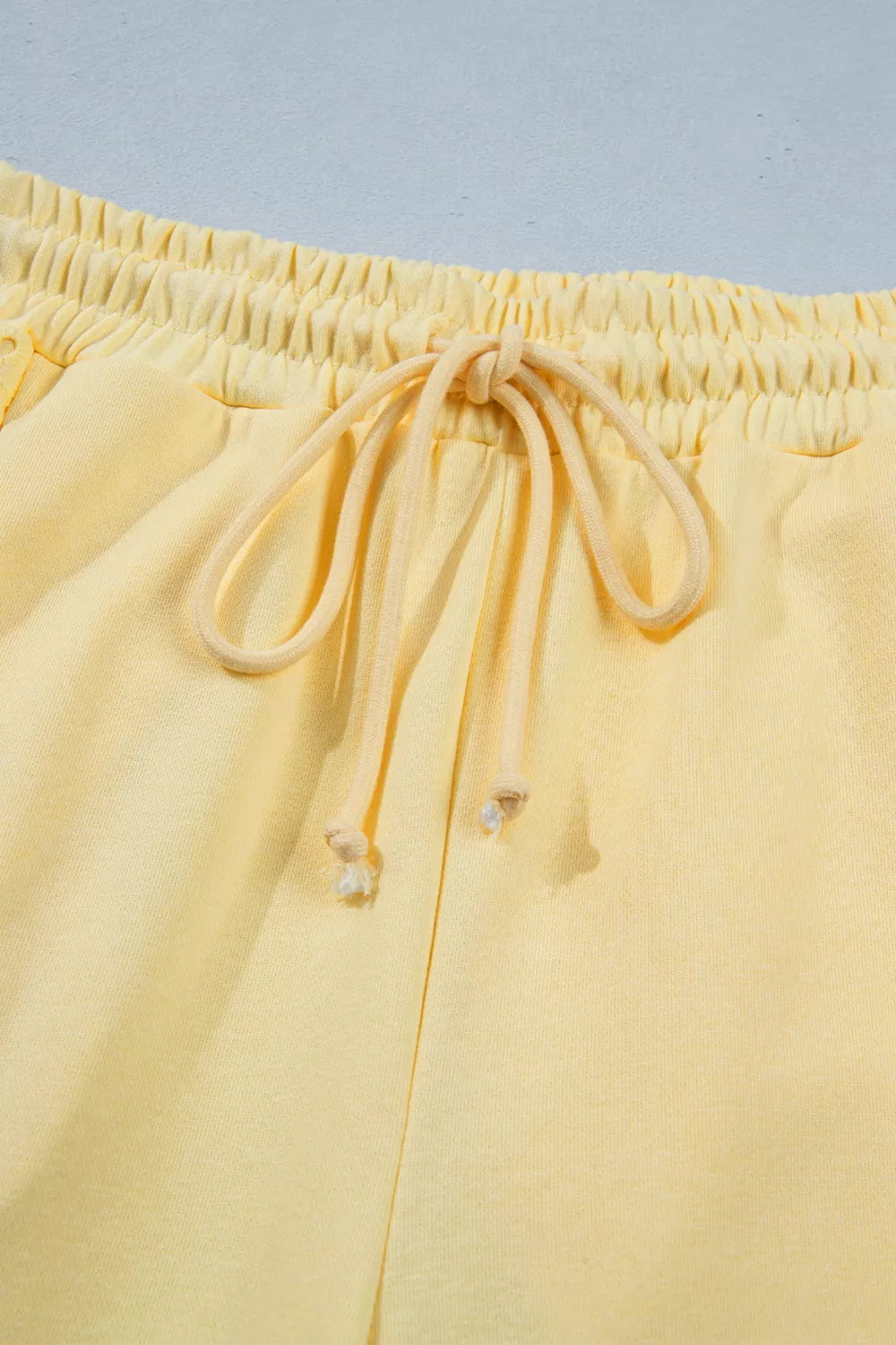 Trendsi half sleeve top and drawstring pants set with rings detail, casual matching ensemble, in soft fabric and neutral tones.