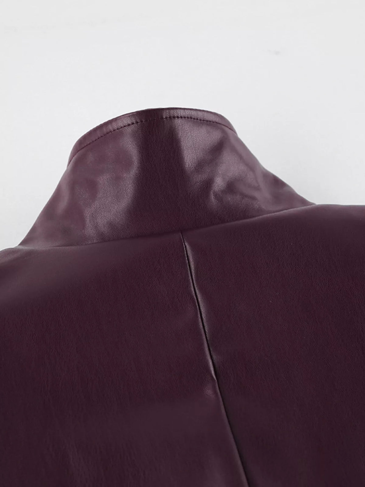 Women's belted faux leather jacket with stand collar from Trendsi, featuring a sleek design and stylish details.