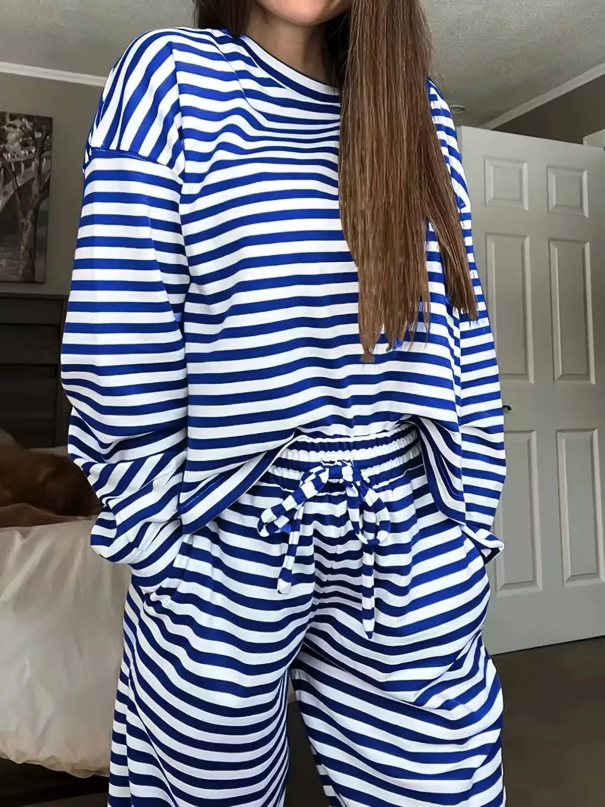 Striped dropped shoulder top and matching pants set by Trendsi, featuring a relaxed fit and stylish design.