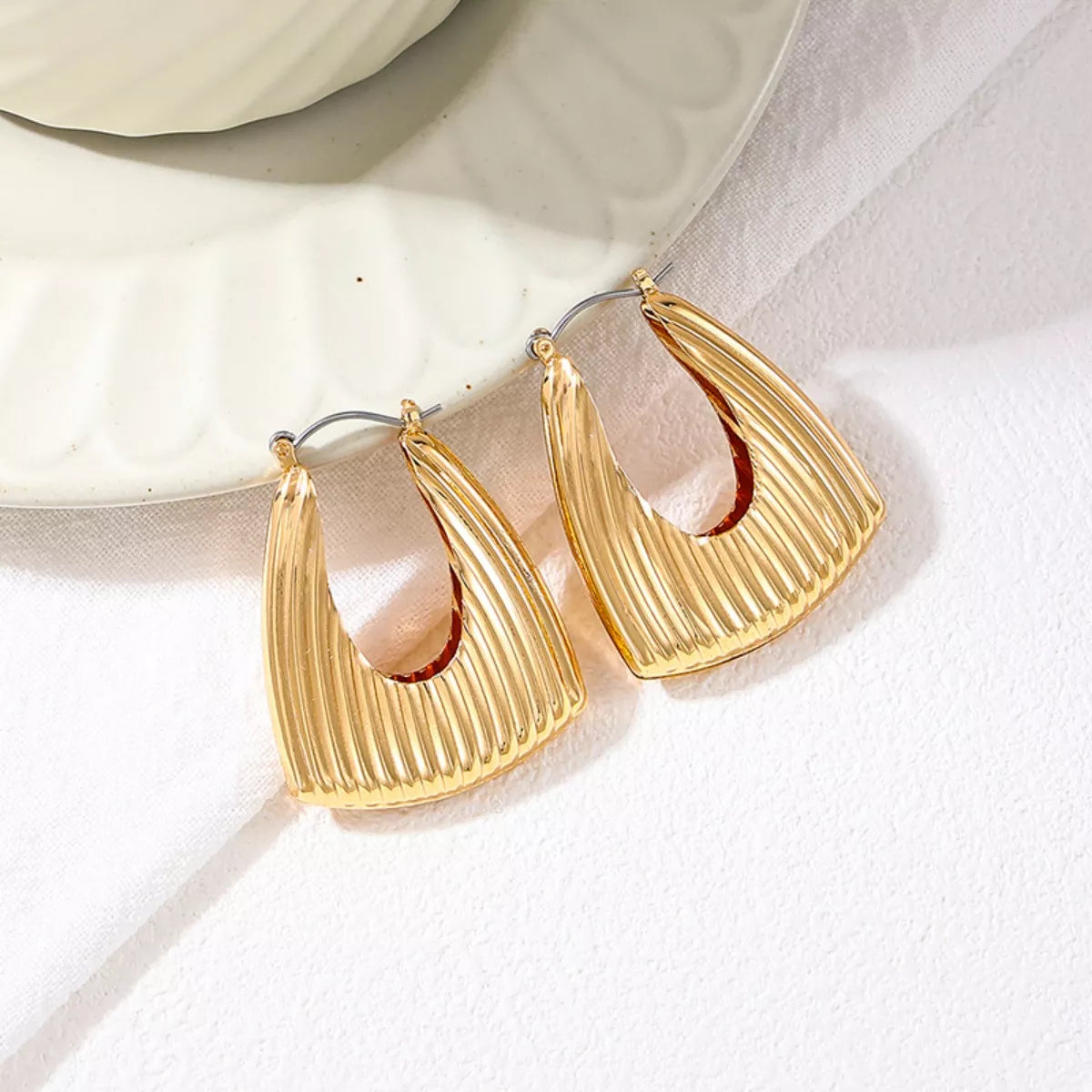 Gold-plated alloy triangular hoop earrings with ribbed design, stylish jewelry by Plush Fashion Hub.