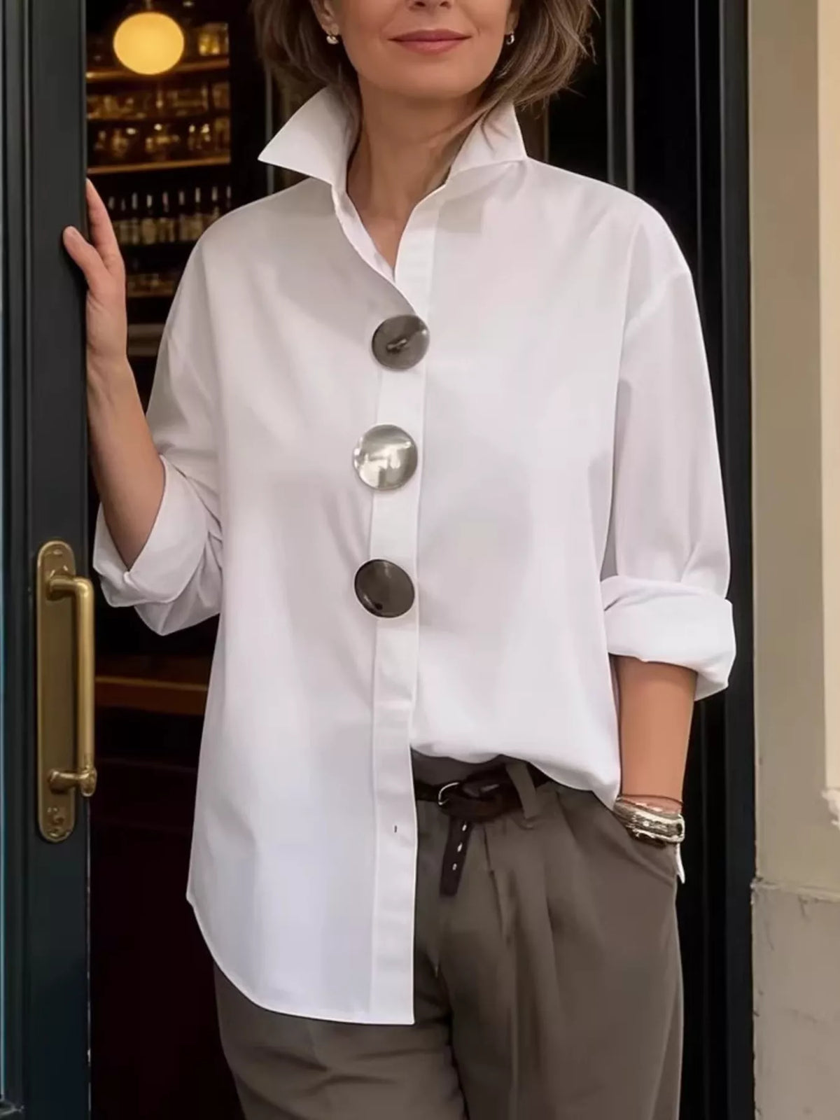 Plus size oversized metal button long sleeve shirt by Trendsi, showing a relaxed fit with metallic buttons and long sleeves.