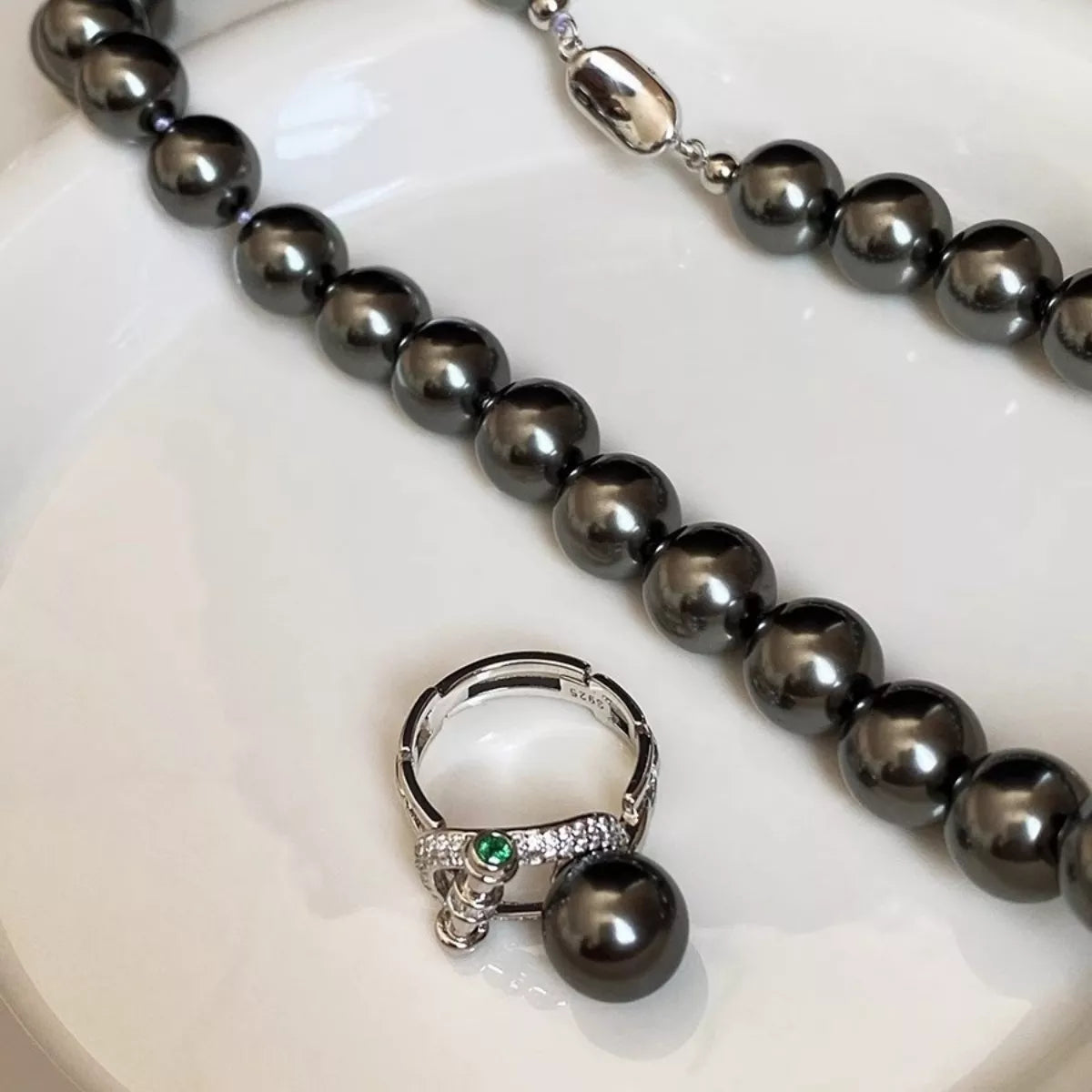 Sterling silver zircon pearl ring with intricate design, showcasing a shiny pearl and sparkling zircon stones on a polished band.