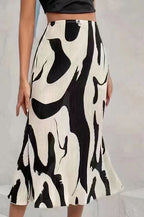 Women's zebra print pleated casual skirt with irregular hem and side slit, by FitiqueFit, shown on a model.
