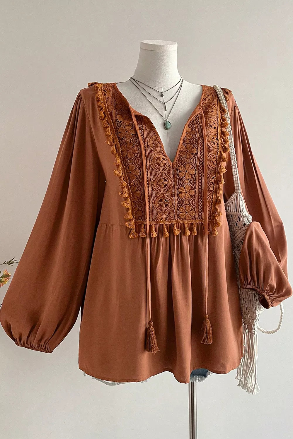 Plus size V-neck embroidered tassel long sleeve blouse from Trendsi, featuring intricate embroidery and flowy fabric.