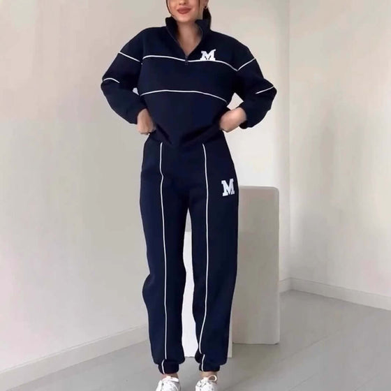 Stylish woman in navy hoodless pullover and matching sweatsuit set with pockets and sporty stripes.