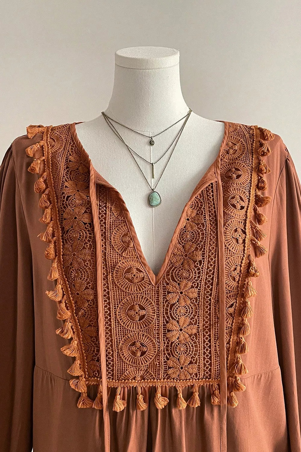 Plus size V-neck embroidered tassel long sleeve blouse from Trendsi, featuring intricate embroidery and lightweight fabric.