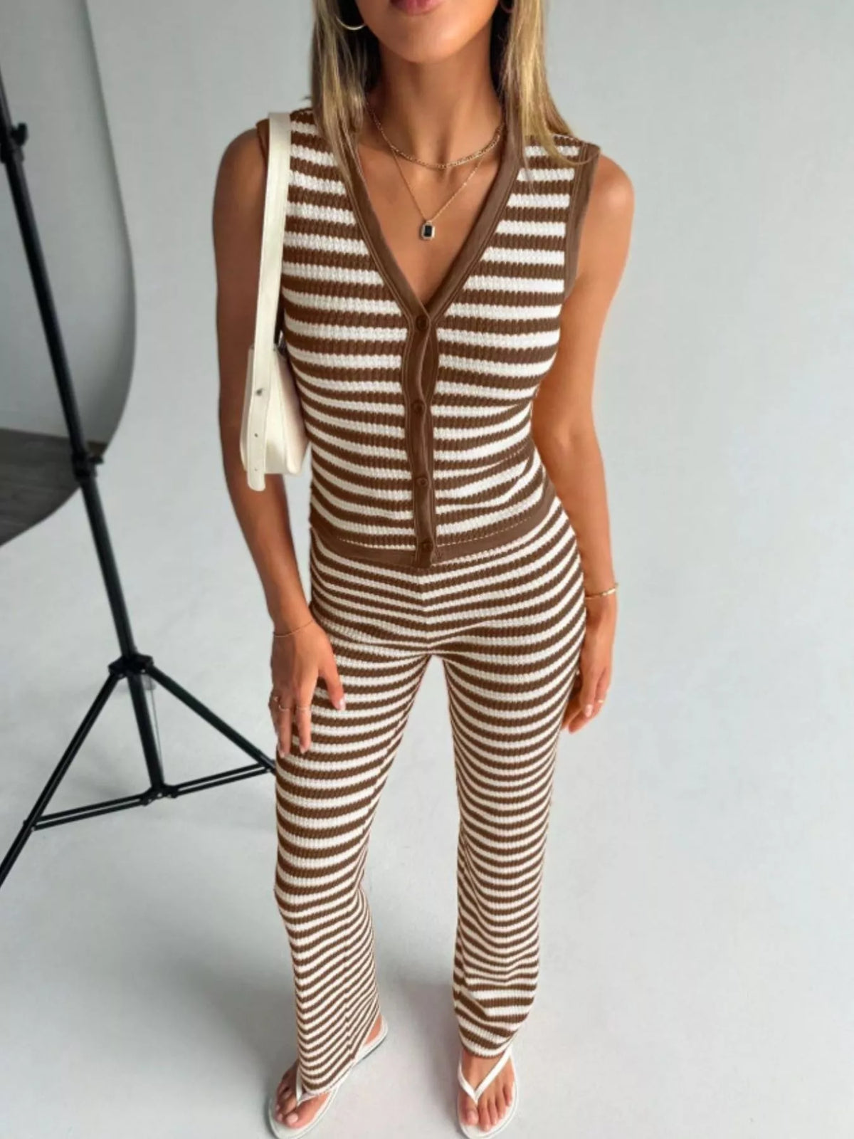 Striped knit V-neck sleeveless top and flare pants set by Plush Fashion Hub, casual stylish outfit with a comfortable fit.