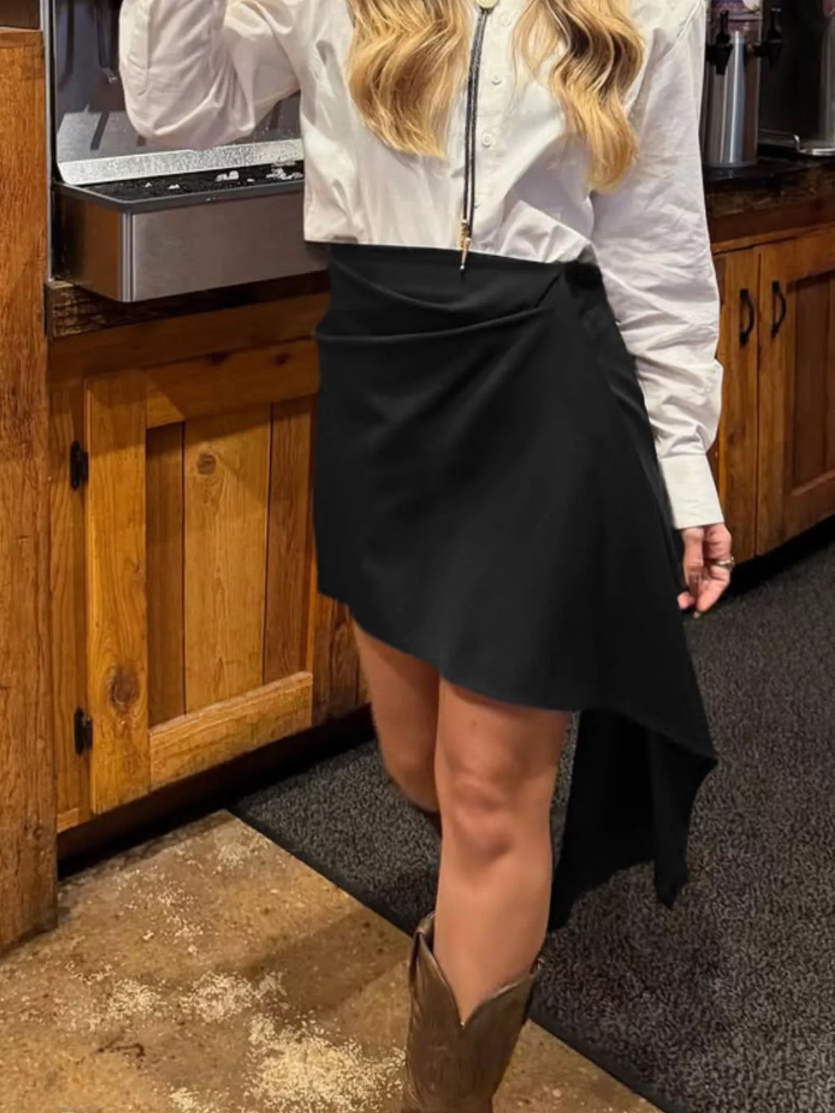 Asymmetric high-waisted draped mini skirt from Trendsi, shown in black with stylish, flowing fabric and modern design.