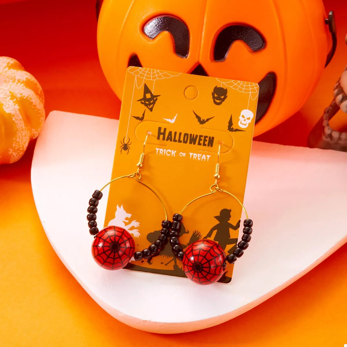 Gold-plated Halloween bead earrings with spooky design, featuring vibrant orange and black beads, from Plush Fashion Hub.