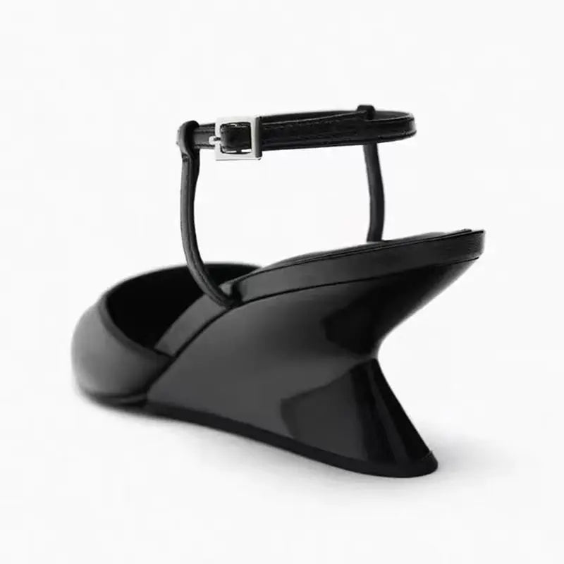Elegant black patent leather wedge sandals with a sleek architectural heel and an adjustable ankle strap.