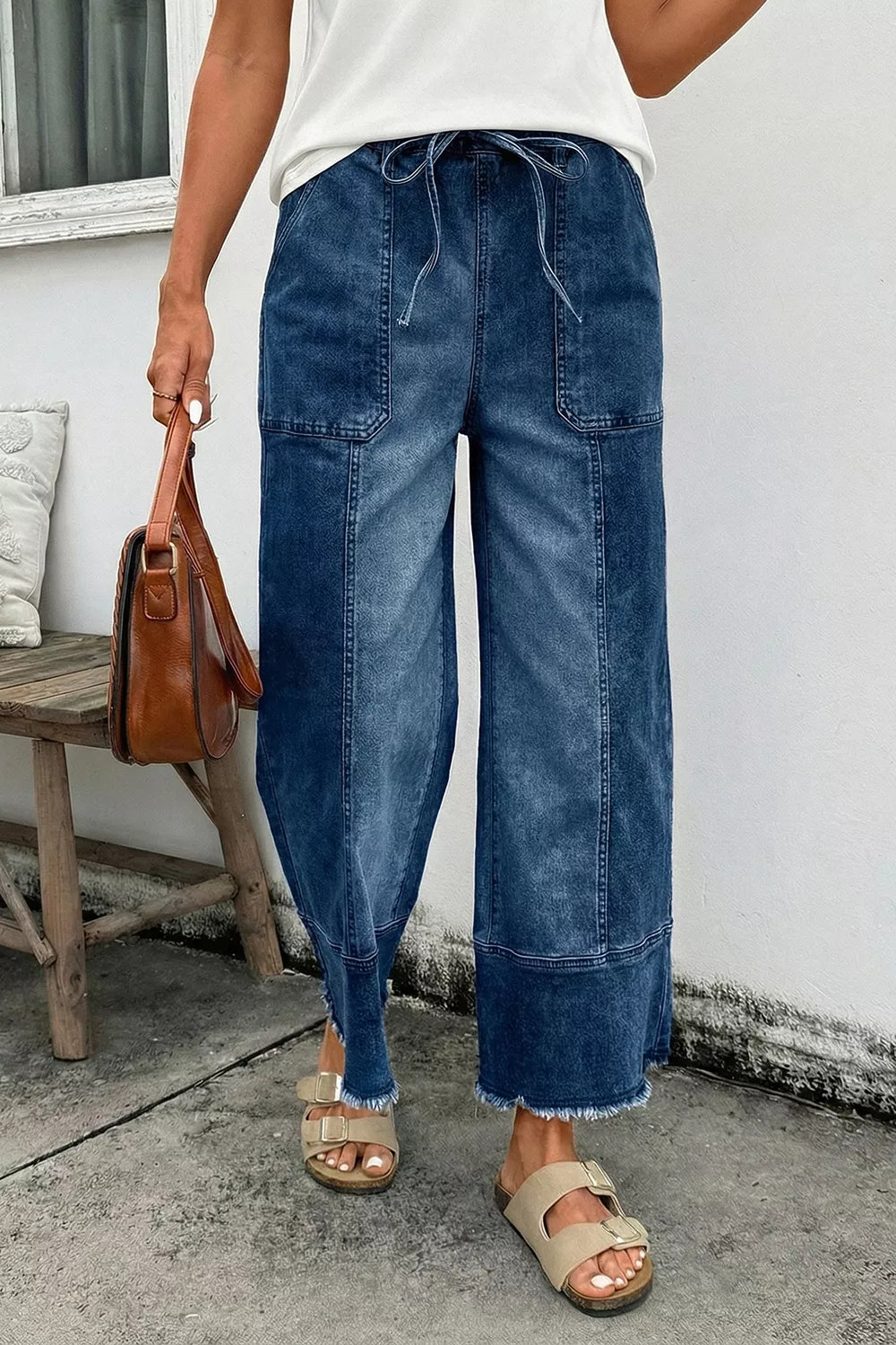 Wide-leg denim pants with drawstring waist, seam details, raw hem, and a relaxed fit from Plush Fashion Hub.