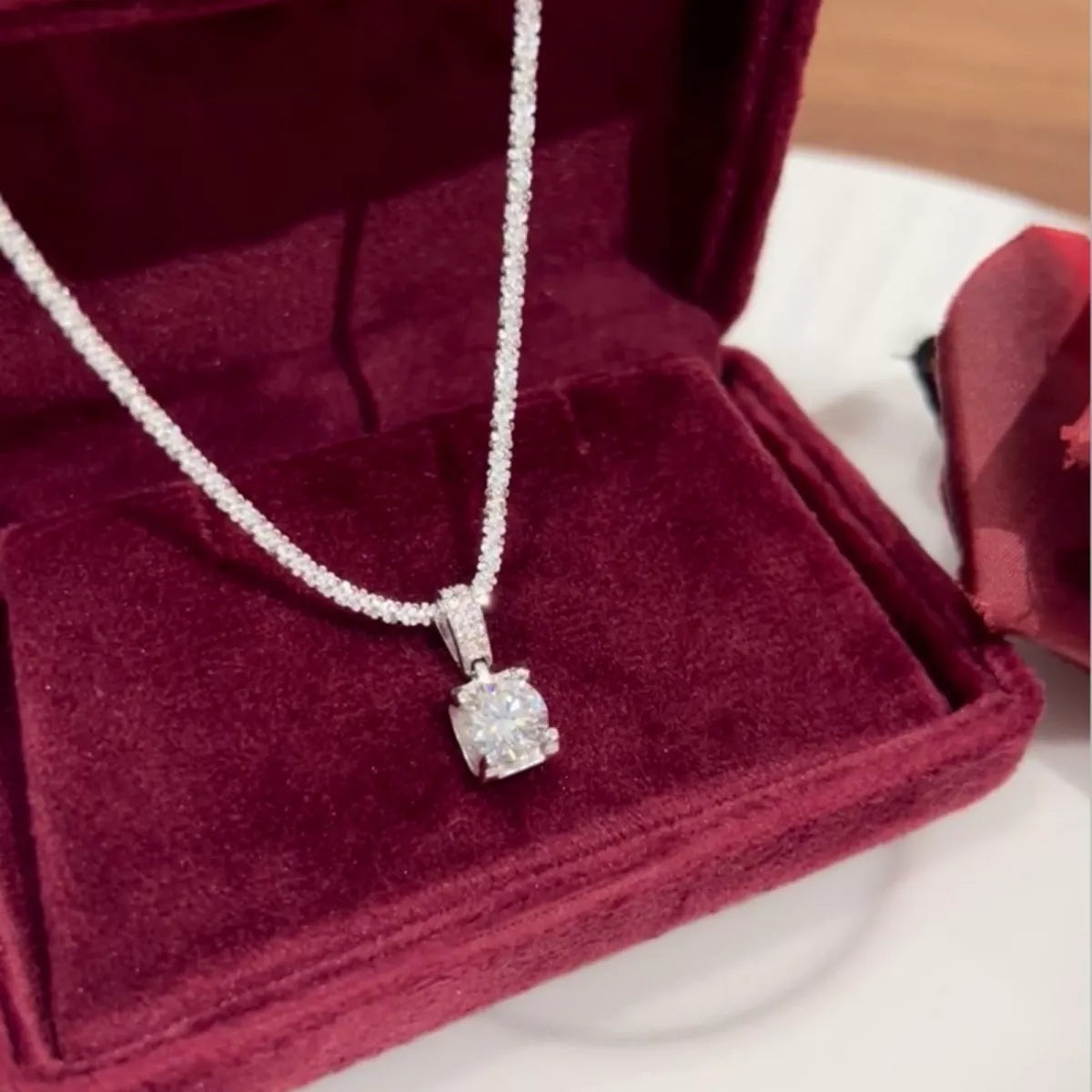 Sterling silver 1 carat moissanite necklace featuring a sparkling round-cut gemstone with a delicate chain.