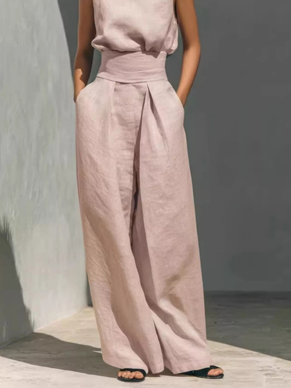 Plus size sleeveless wide-leg jumpsuit with smocked waist, casual full-length jumpsuit by Trendsi, shown on a model.