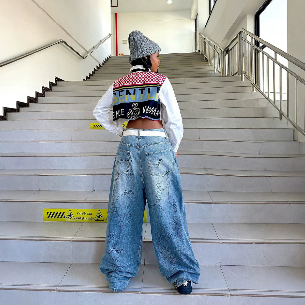 Washed denim jeans with graffiti print by Plush Fashion Hub, showing distressed details and casual fit.