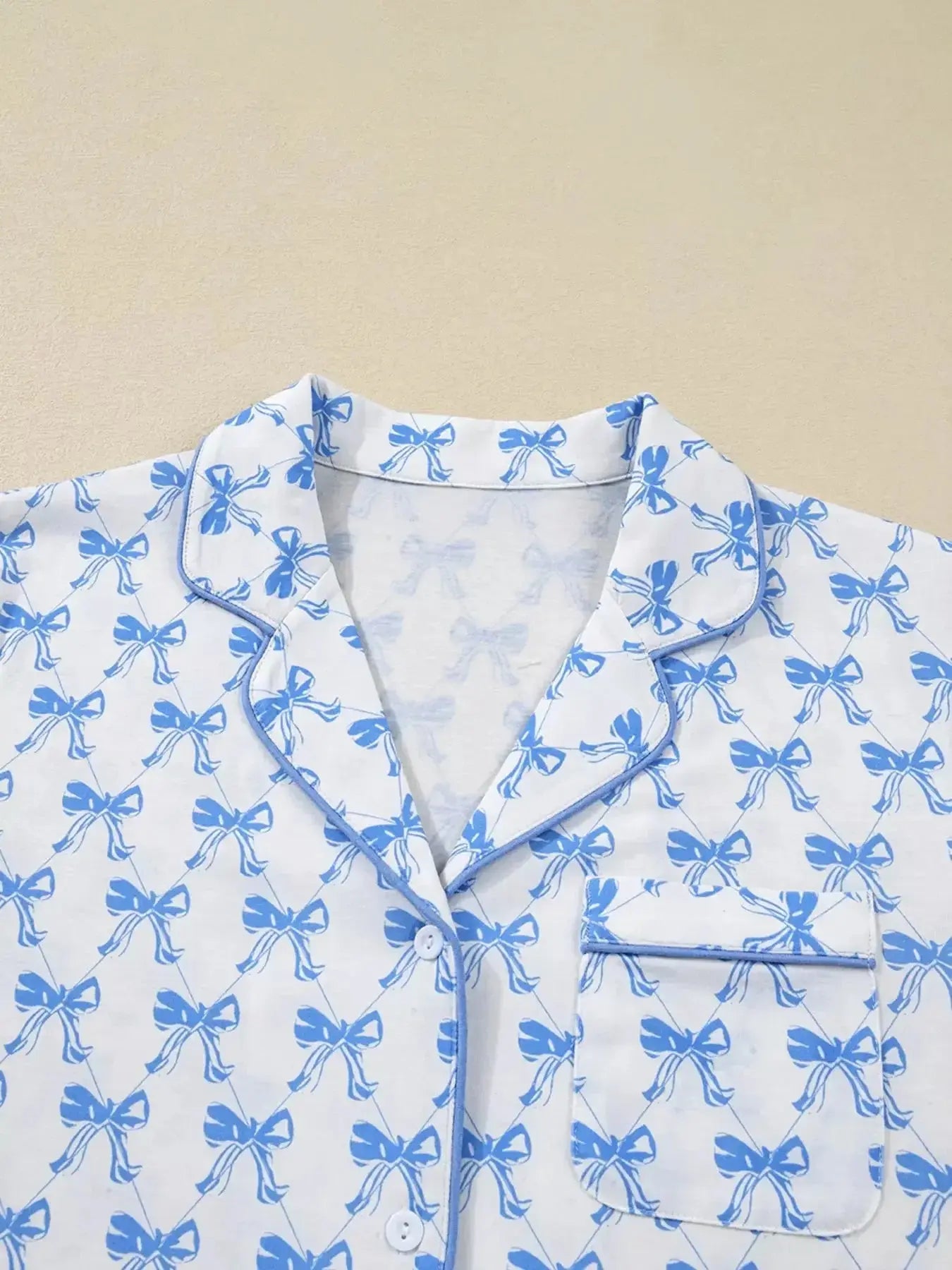 Women's bow print long sleeve pajama set by Plush Fashion Hub featuring a button-down shirt and matching pants in soft loungewear fabric.