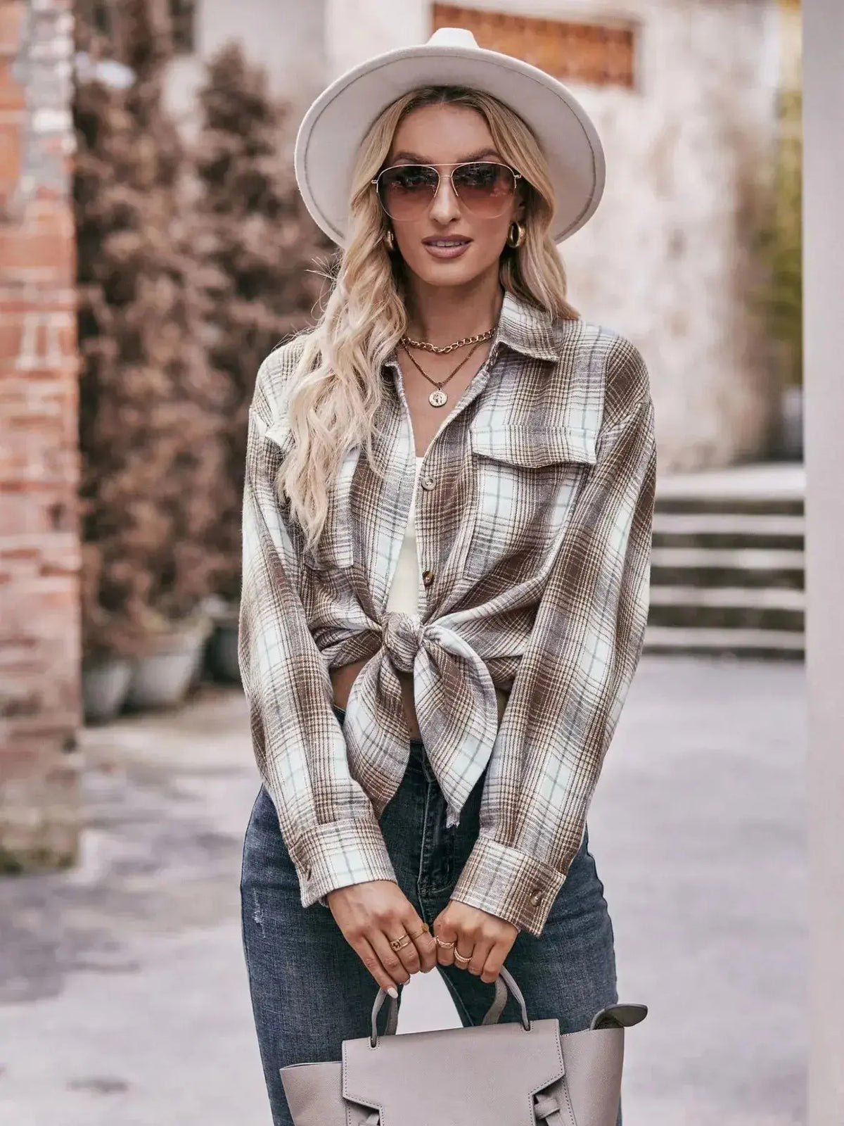 Women's plaid long sleeve button-down shirt by Plush Fashion Hub, featuring a classic pattern and tailored fit.