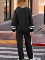 Contrast-trim round neck lounge set with cozy two-piece top and pants by Trendsi, featuring comfortable fabric and relaxed fit.