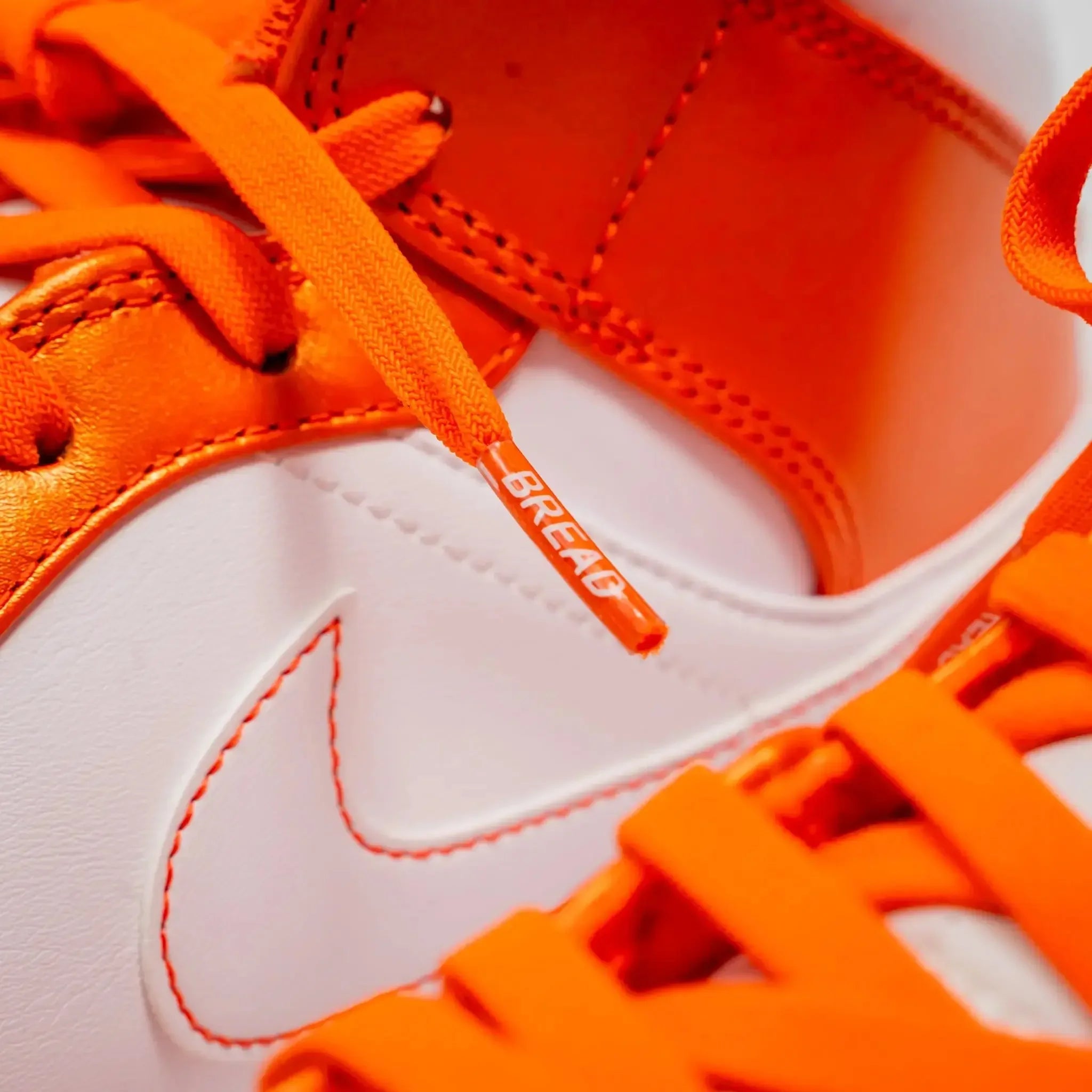 Coral orange elastic shoelace by Bread, showing the flexible, vibrant coral-orange color and elastic texture for easy wear.