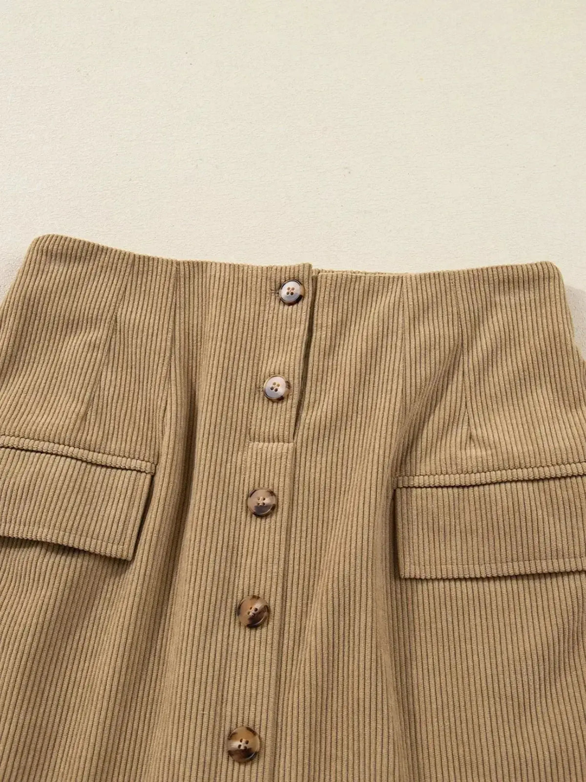 Women’s high-waisted corduroy mini skirt with button-front closure by Plush Fashion Hub, showcasing a stylish and textured design.
