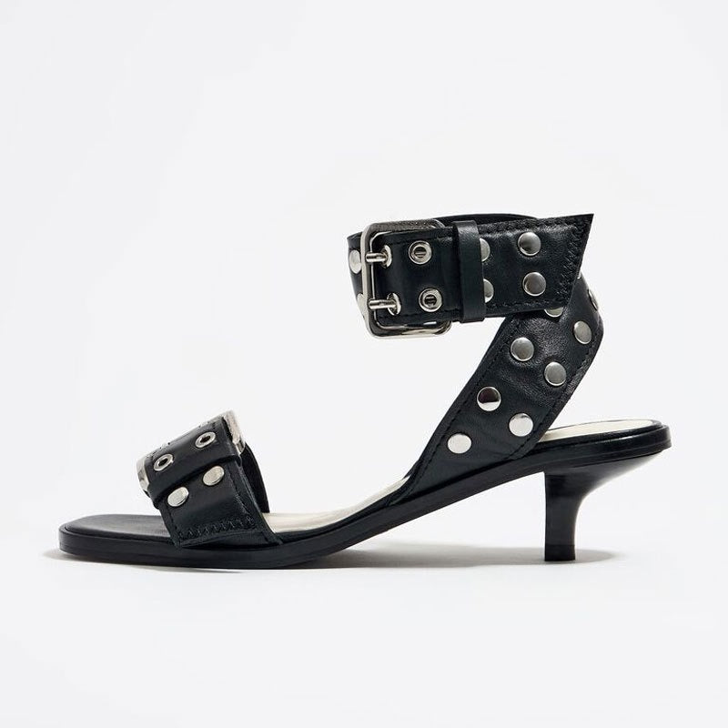 Black leather strappy mid-heel sandals with silver metal rivets and buckle closures.