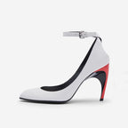 Modern white leather pointed-toe stiletto with ankle strap, buckle, and colorblocked black and red sculptural heel.