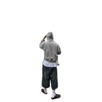 Person wearing dark wash, vintage-style wide-leg denim shorts with a distressed finish, paired with a grey hoodie.