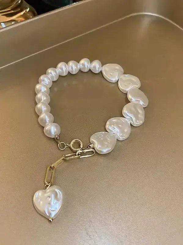 Elegant heart-shaped pearl beaded bracelet with stainless steel clasp by Plush Fashion Hub, perfect for stylish accessories.