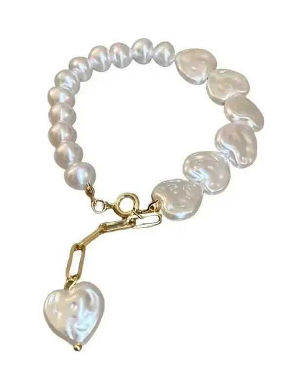 Elegant heart-shaped pearl beaded bracelet with stainless steel clasp by Plush Fashion Hub, showcasing delicate jewelry design.