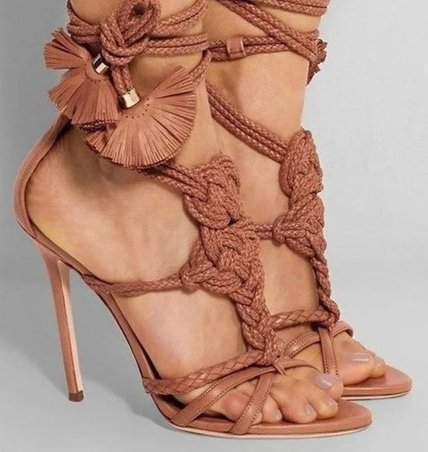 Tan braided stiletto lace-up sandals with wrap-around ties, knotted details, and dangling pleated tassels.