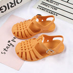 Girls hollow casual flat sandals in pink with open toe design, featuring adjustable straps and trendy style from Trendy Attic Store01.