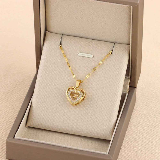 Gold chain necklace with heart-shaped pendant in a jewelry box from Plush Fashions Shop.