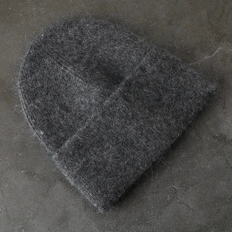 Women solid color fur knitted bonnet in dark gray for warmth and style.