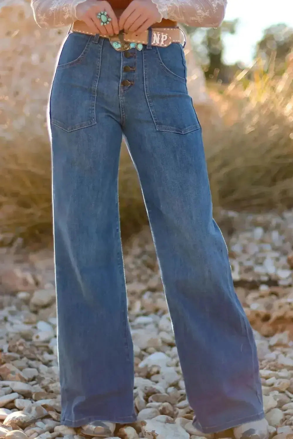 High-waisted wide-leg denim jeans with button front from Trendsi, featuring classic blue wash and relaxed fit for casual style.