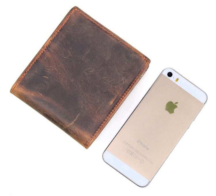 Men's luxury leather wallet beside a smartphone, showcasing premium material and sleek design.