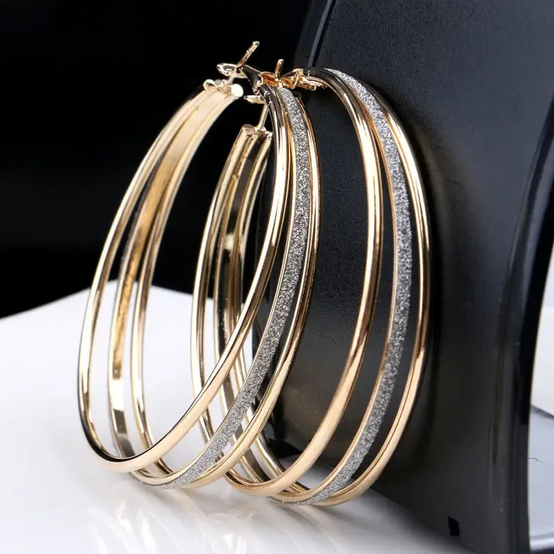 Modern multilayer forked circle earrings in two-tone gold and silver, showcasing layered geometric design.