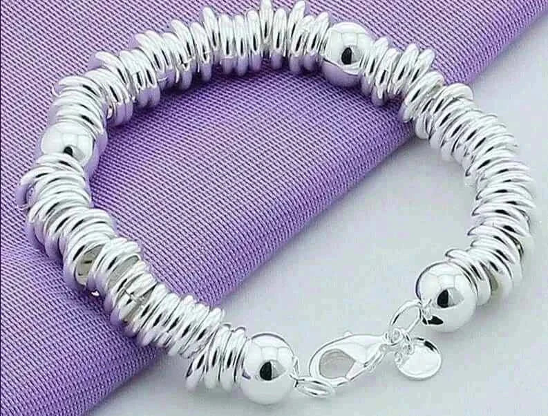 Elegant 925 silver color charm cuff bangle for women on purple fabric.