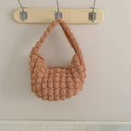 Handmade crocheted beige straw beach bag with hand carry handle, ideal for seaside vacations and casual outings.