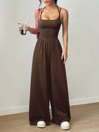 Casual women's summer jumpsuit by Plush Fashion Hub with wide legs, wrapped chest, nipped waist, and suspenders, shown on model.