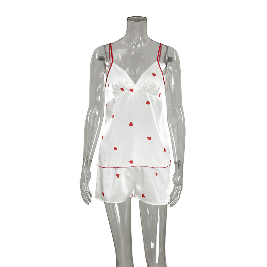 Bella Mia satin women's spring homewear set featuring heart-print suspender shorts and matching two-piece pajama top and bottom.