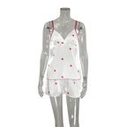 Bella Mia satin women's spring homewear set featuring heart-print suspender shorts and matching two-piece pajama top and bottom.