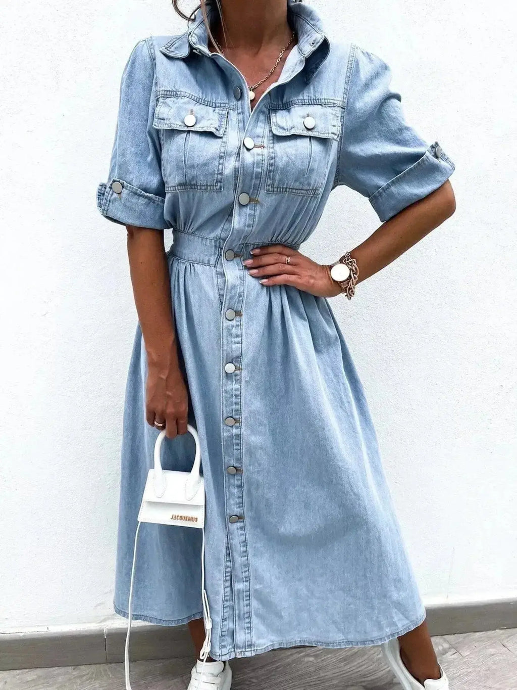 Plus size denim shirt dress by Trendsi featuring roll-up sleeves and front pockets, styled for casual wear.