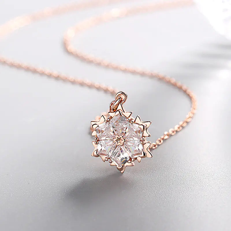 Silver snowflake necklace with diamond pendant, elegant jewelry piece featuring a delicate snowflake design and sparkling accents.