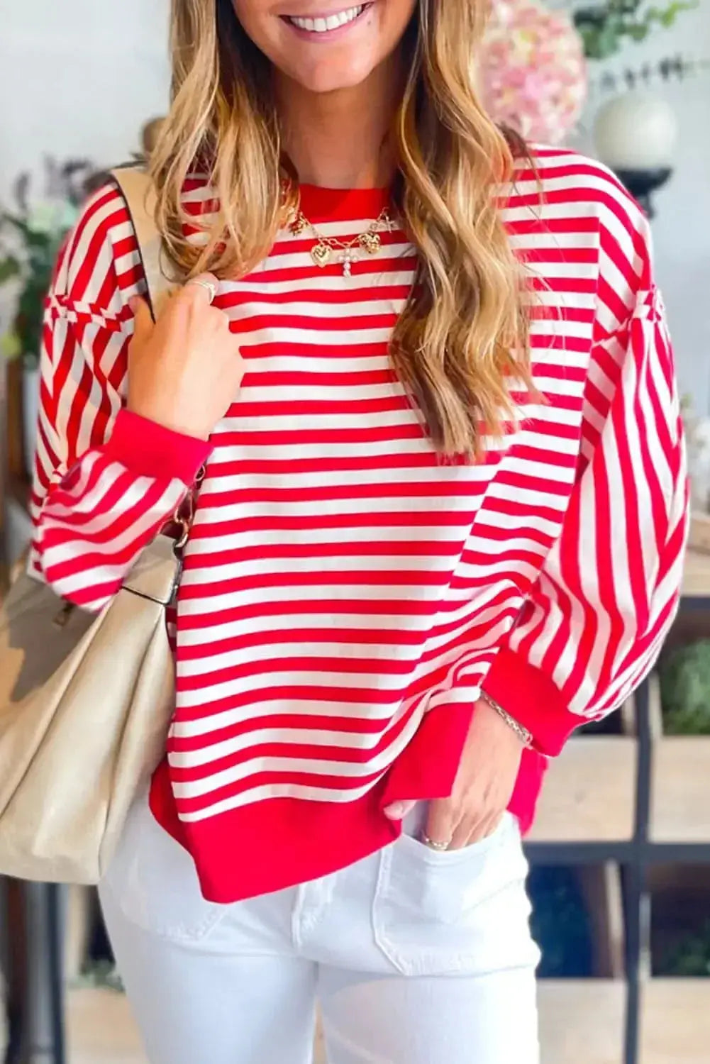 Red striped drop shoulder long sleeve top with exposed seams from Gilded Glamour Shop, showcasing a casual and stylish design.
