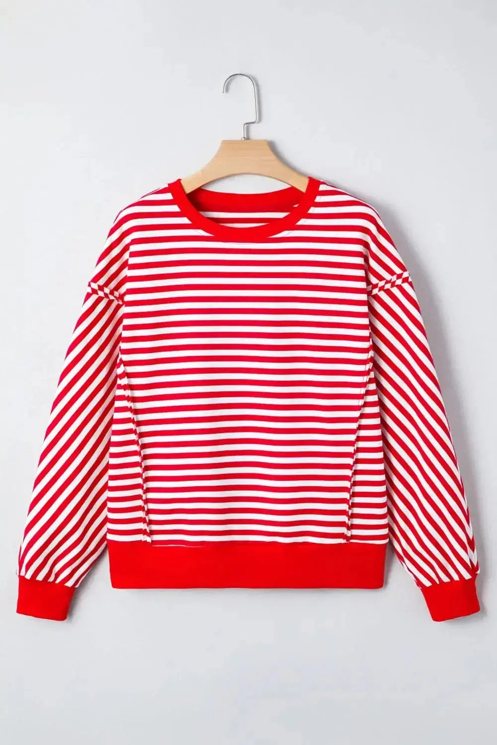 Red striped drop shoulder long sleeve top with exposed seams by Plush Fashion Hub, featuring a relaxed fit and casual style.