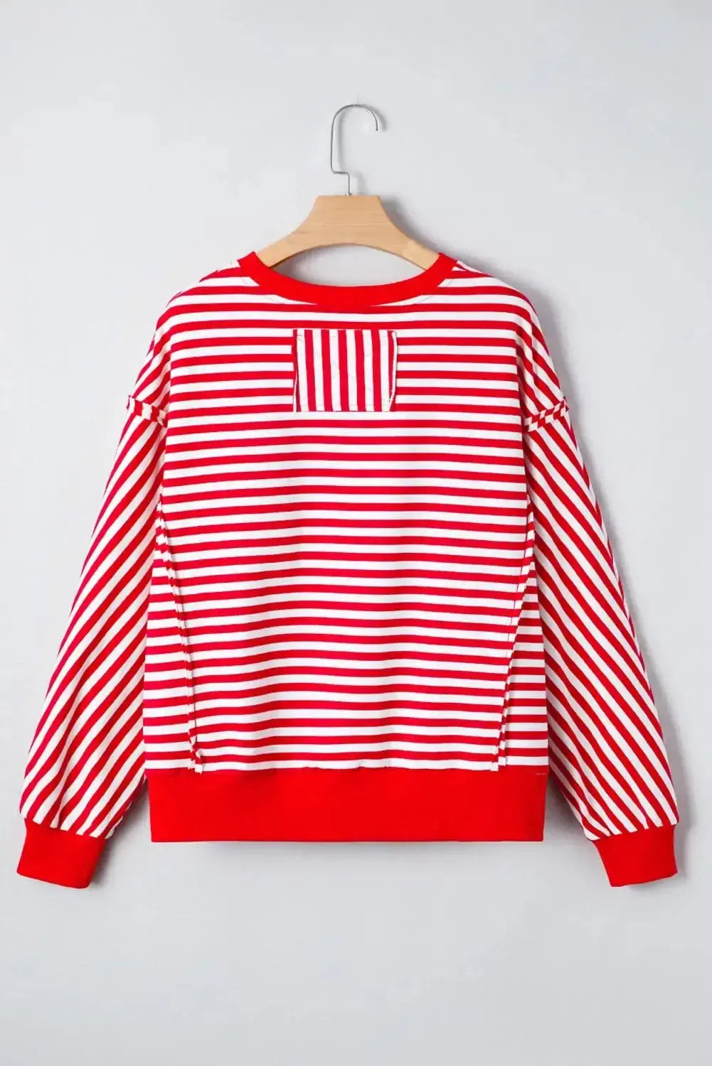 Red striped drop shoulder long sleeve top with exposed seams from Plush Fashion Hub, featuring a relaxed fit and casual style.