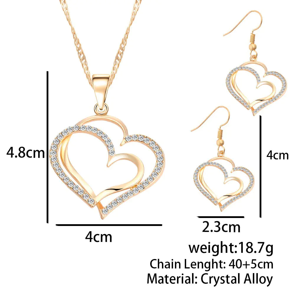 Double heart earrings and necklace wedding set featuring silver-tone jewelry with delicate heart charms and intricate detailing.