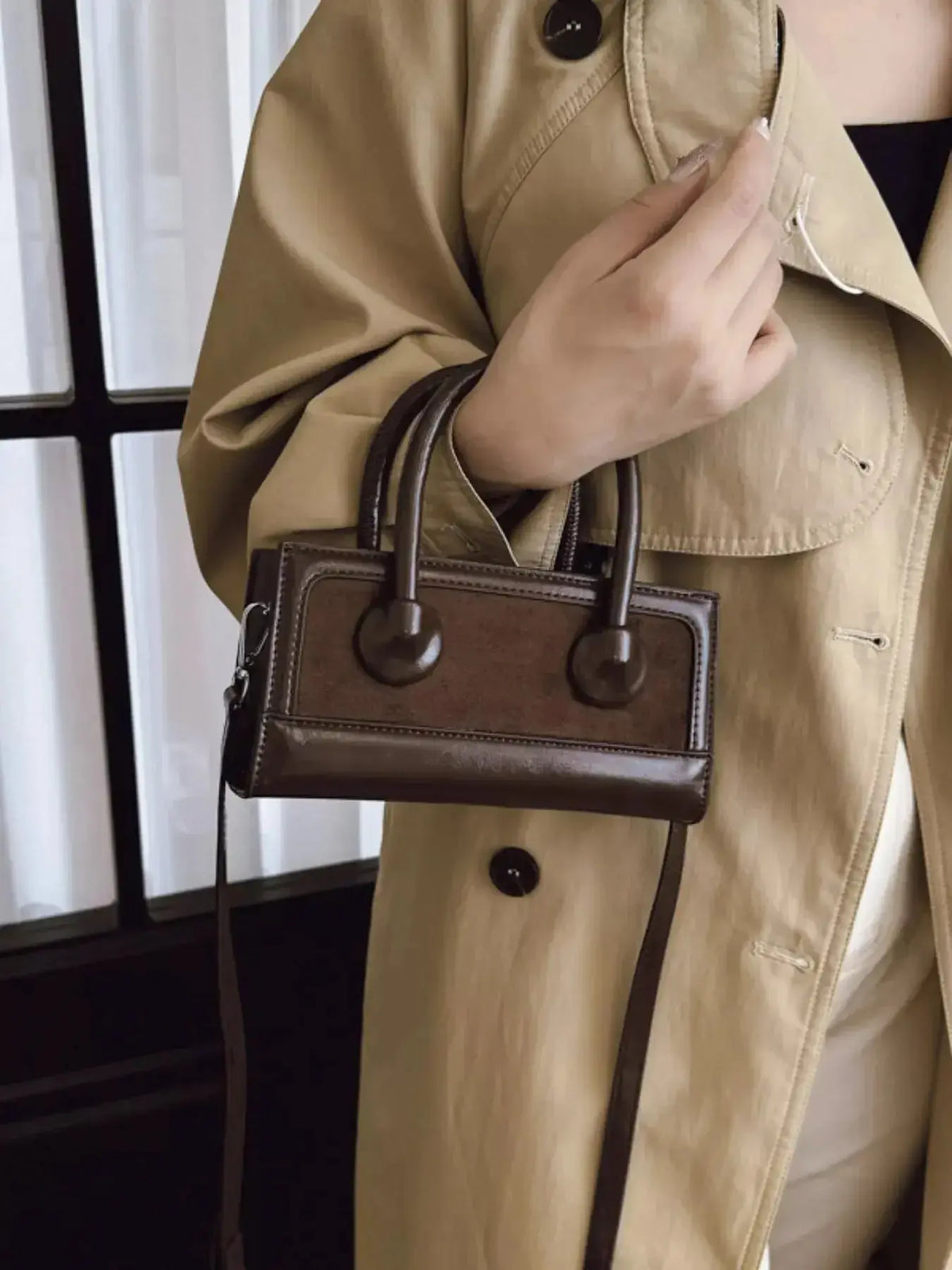 Structured leather crossbody handbag with a top handle, featuring a sleek design and plush leather finish by Plush Fashion Hub.